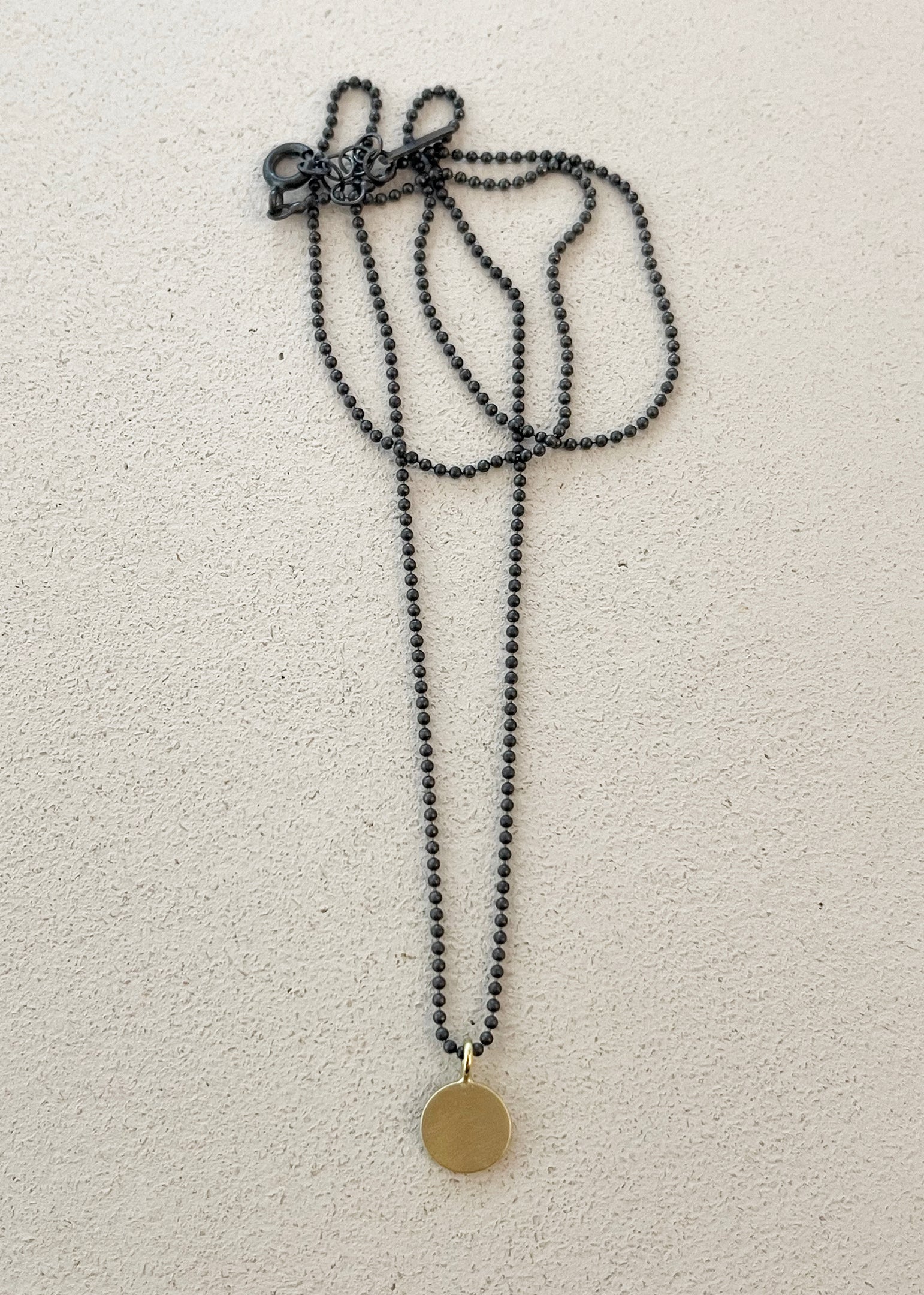 Flat disk with ball chain necklace